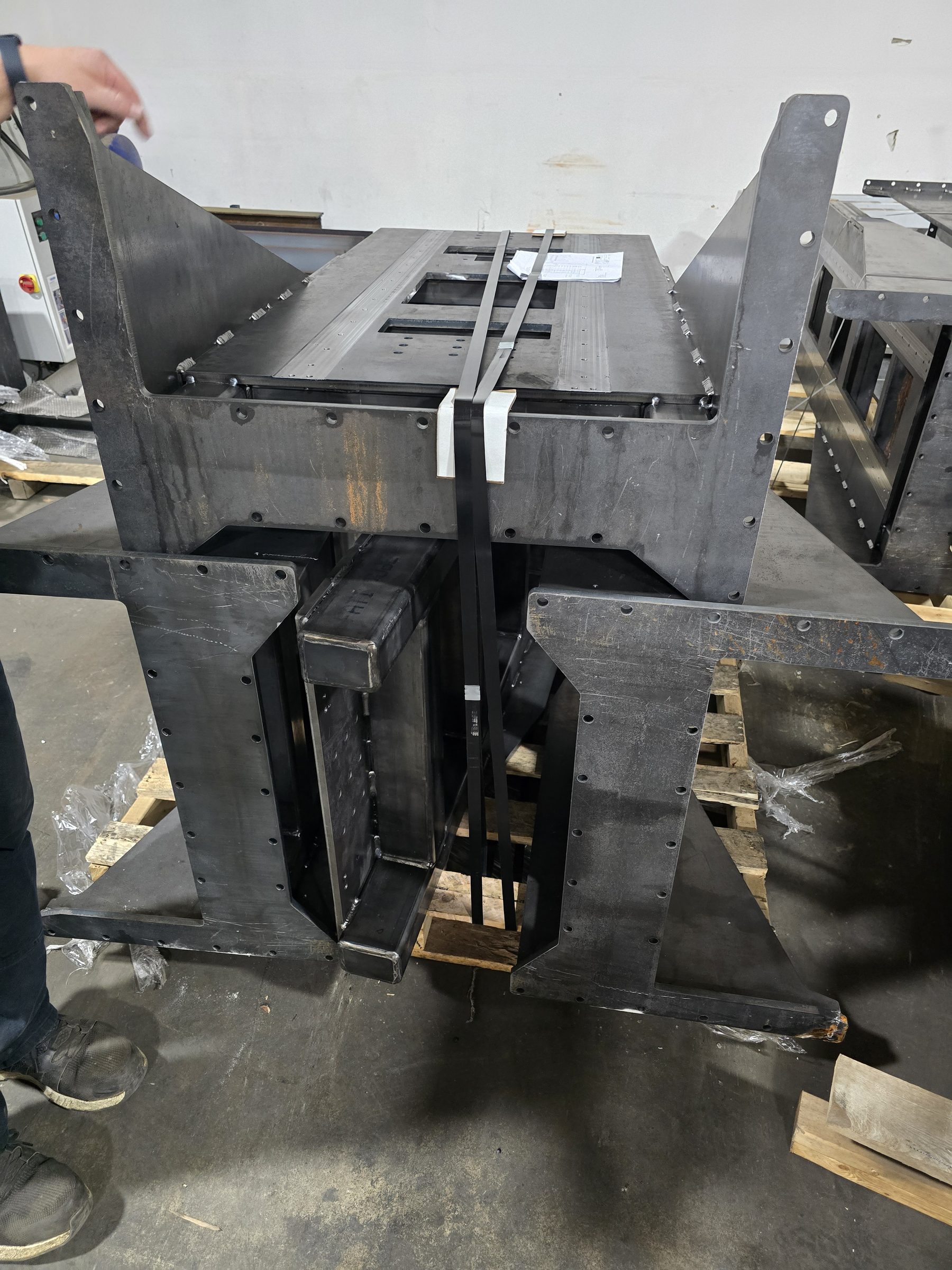 Raw welded steel weldment for a machine base, uncoated, on the fabrication floor