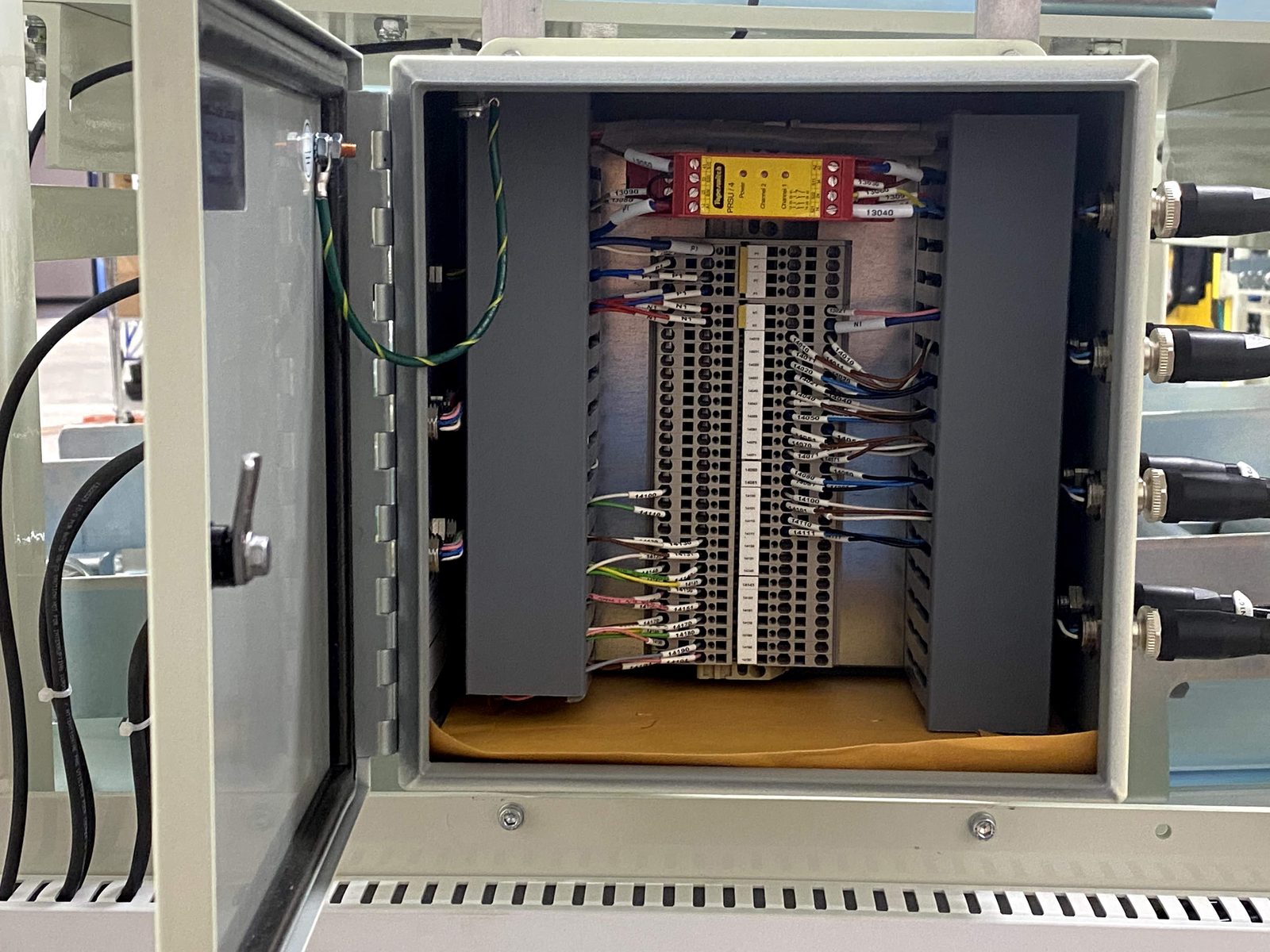 Terminal rails and distribution wiring inside an open control cabinet